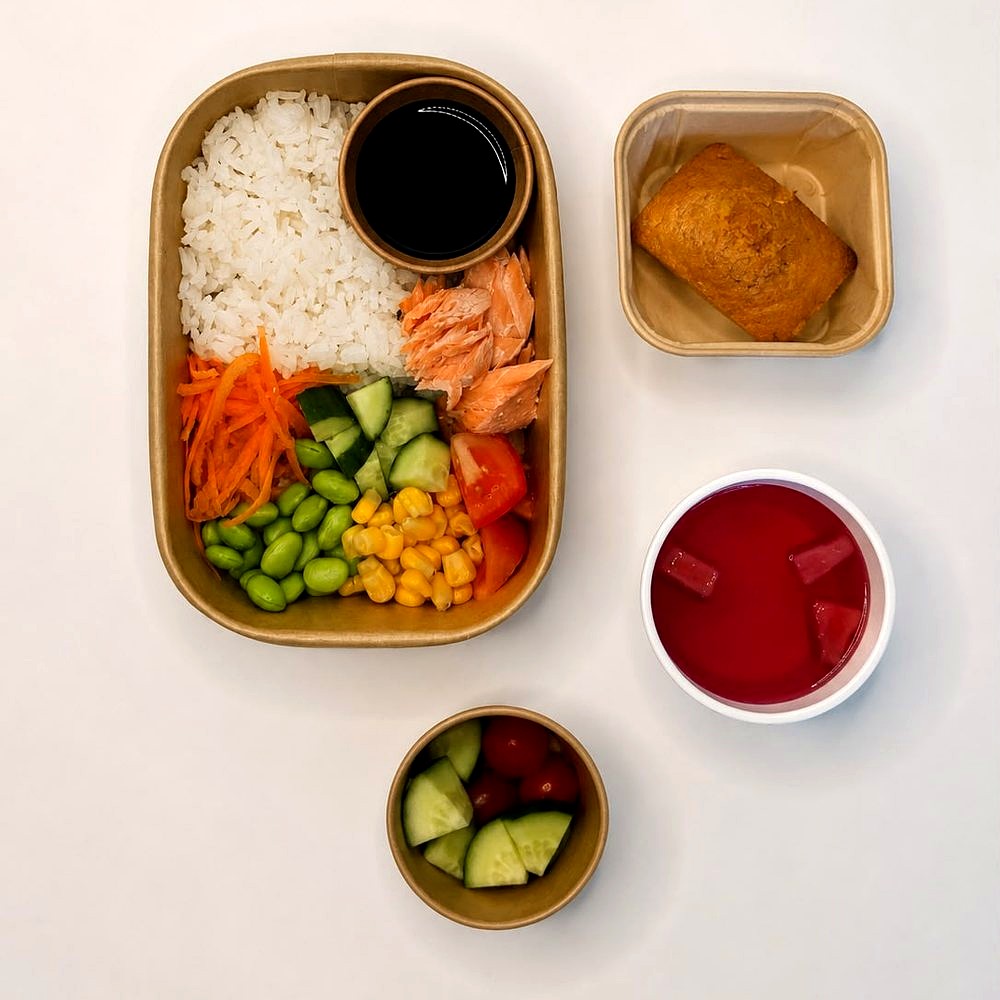 Salmon with rice, soy sauce, edamame, sweetcorn, carrot, cucumber and tomato, with a fruit pot, banana bread and fruit jelly