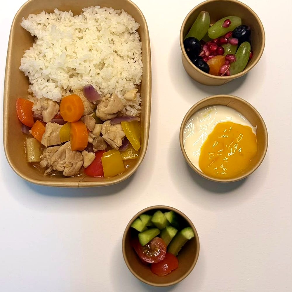 Sweet and sour chicken with rice and fresh veg, a fruit pot, yoghurt with mango, and a cucumber and tomato pot
