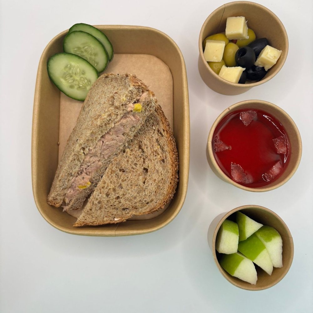 Tuna and sweetcorn sandwich on wholemeal bread with cucumber, olives, cheese, fruit jelly and fresh apple